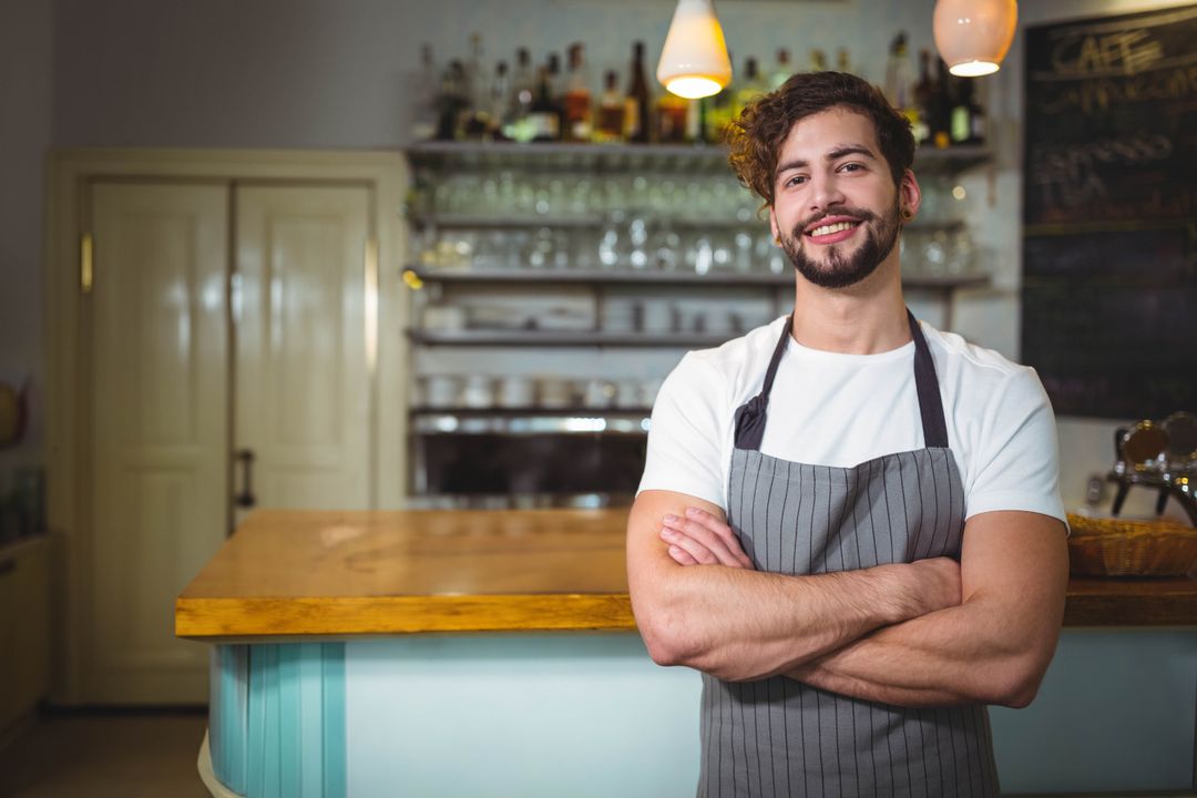 Smiling Young Bartender in Café with Crossed Arms