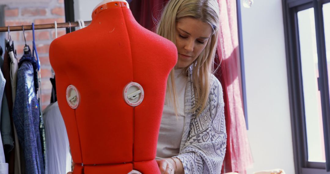 Fashion Designer Adjusting Red Mannequin in Creative Studio - Free Images, Stock Photos and Pictures on Pikwizard.com