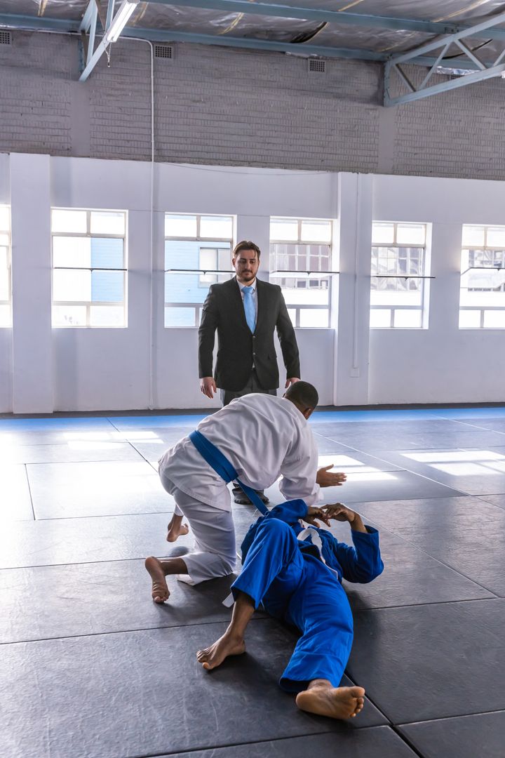 Referee Observing Grappling Martial Artists in Dojo