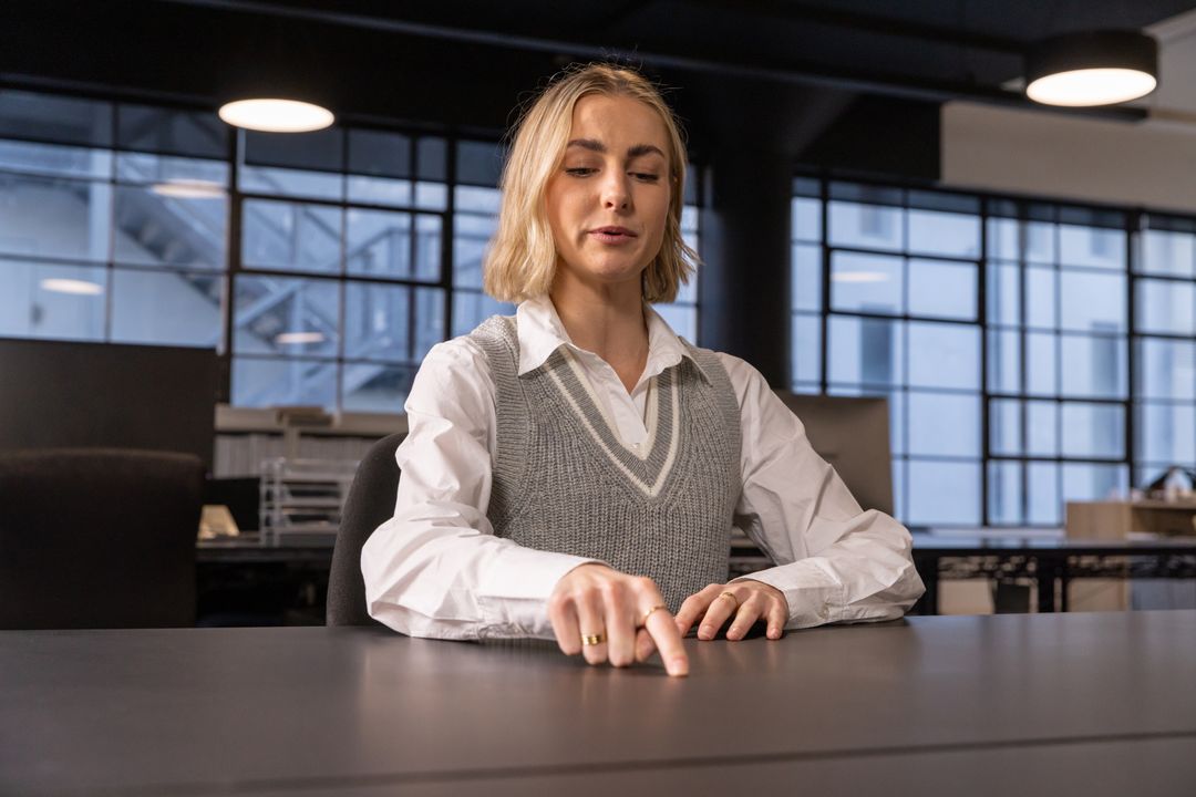 Woman Touching Conference Table in Minimalist Office Space