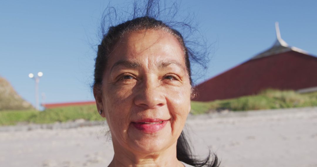 Elderly Woman Smiling Happily in Bright Sunlight at Beach - Free Images, Stock Photos and Pictures on Pikwizard.com