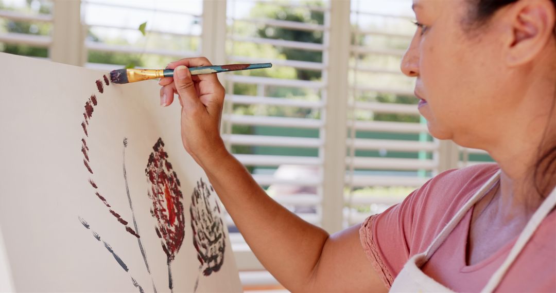 Woman Expresses Creativity Through Painting on Canvas at Home