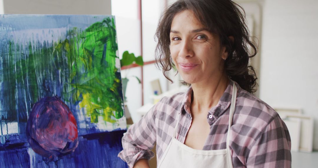 Smiling Female Artist Posing with Abstract Painting in Studio - Free Images, Stock Photos and Pictures on Pikwizard.com