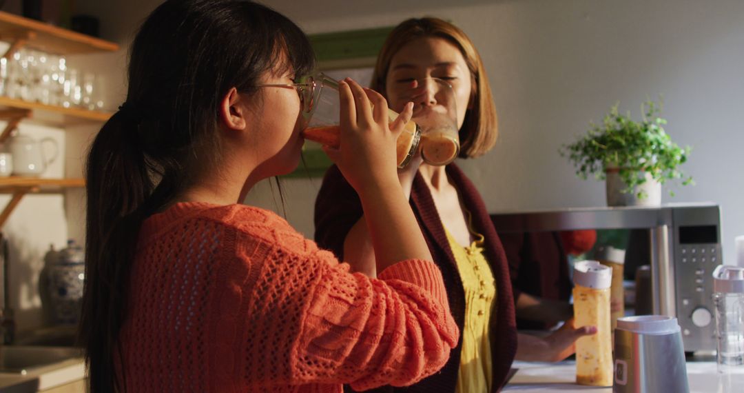 Two Women Drinking Smoothies in a Cozy Kitchen - Free Images, Stock Photos and Pictures on Pikwizard.com