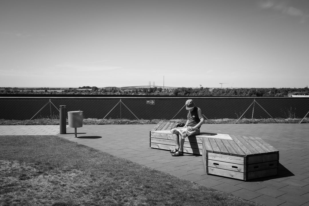 Man Reading Alone on Rooftop Terrace on Sunny Day - Free Images, Stock Photos and Pictures on Pikwizard.com