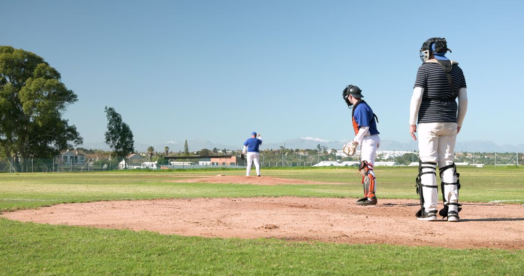 Catcher and Team Practicing on Sunny Baseball Field