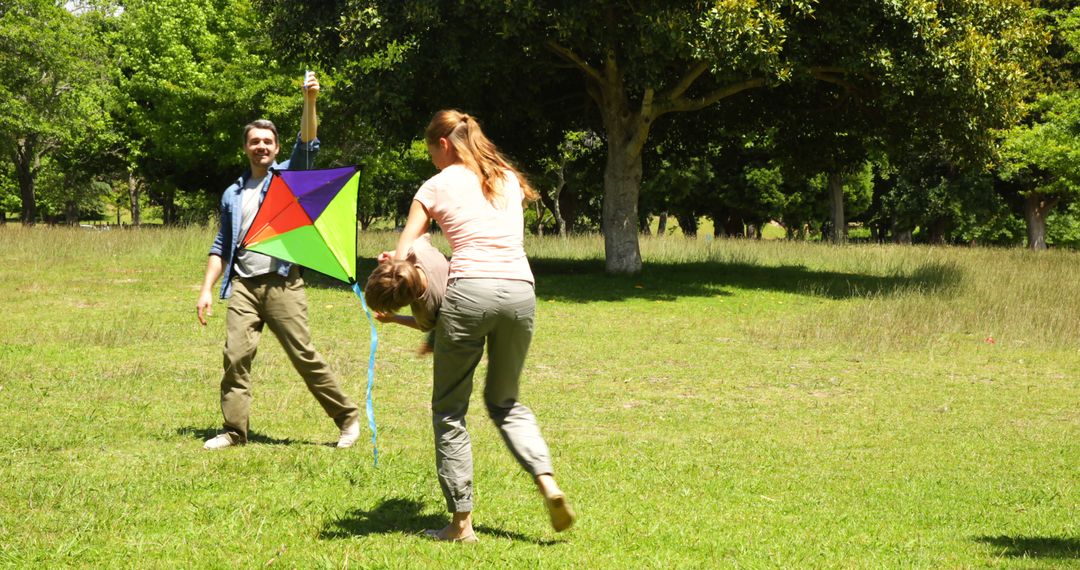 Family Enjoying Sunny Day Flying Colorful Kite in Park - Free Images, Stock Photos and Pictures on Pikwizard.com