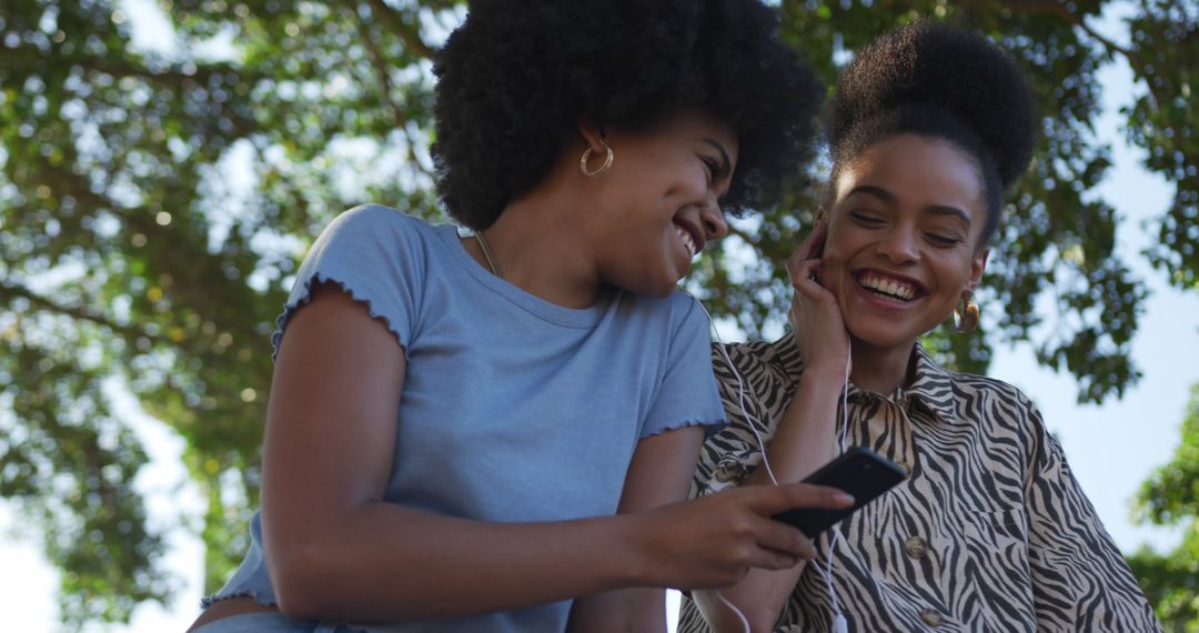 Smiling Friends Enjoying Music Together in Park