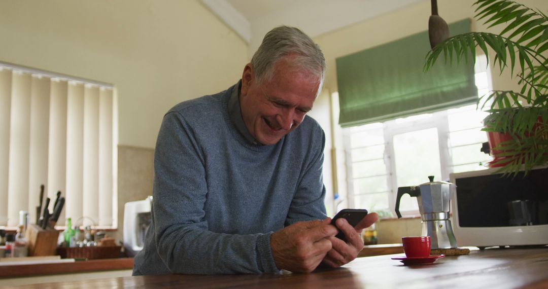 Senior Man Enjoying Smartphone in Modern Kitchen - Free Images, Stock Photos and Pictures on Pikwizard.com