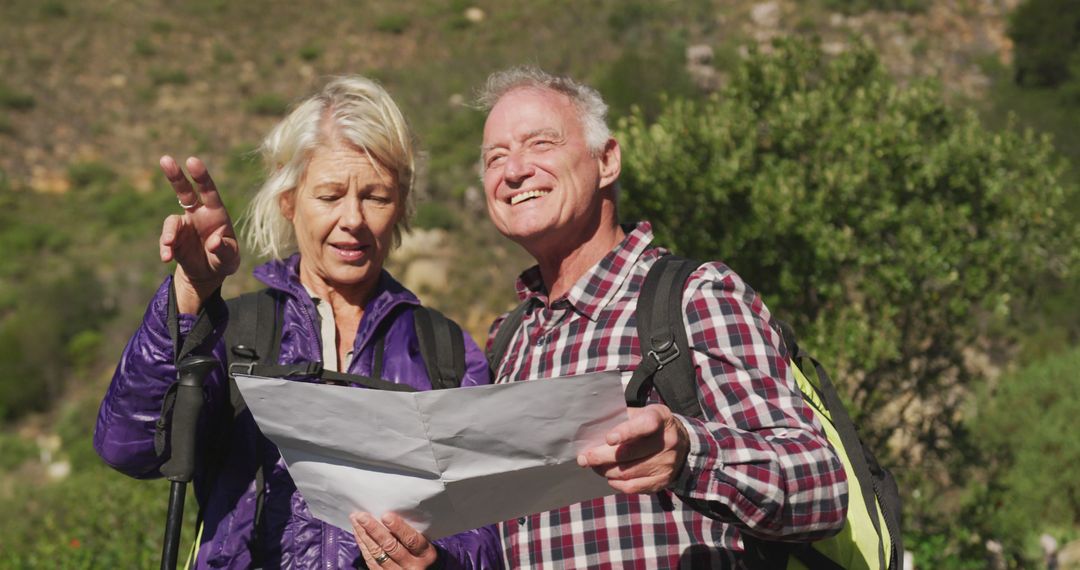Senior Couple Hiking with Map in Scenic Mountain Background