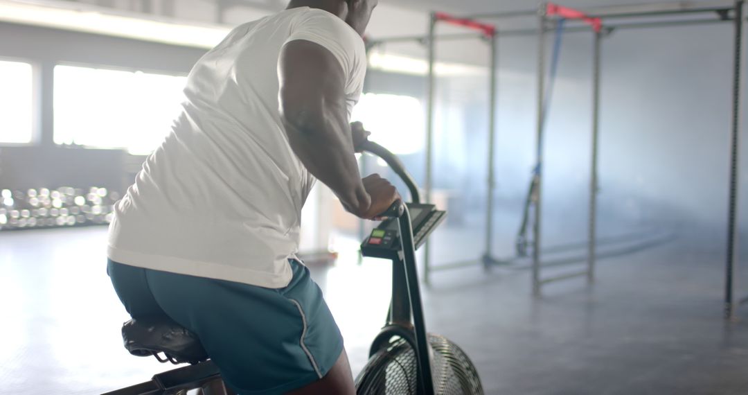 Man Exercising on Stationary Bike in Modern Gym Environment