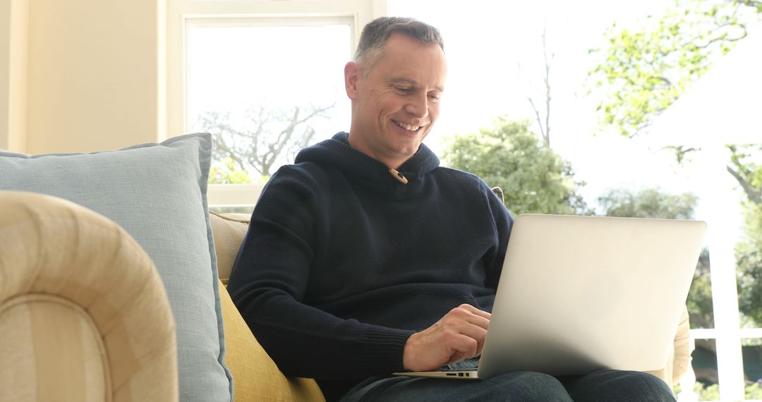 Smiling Middle-aged Man Using Laptop On Sofa At Home - Free Images, Stock Photos and Pictures on Pikwizard.com