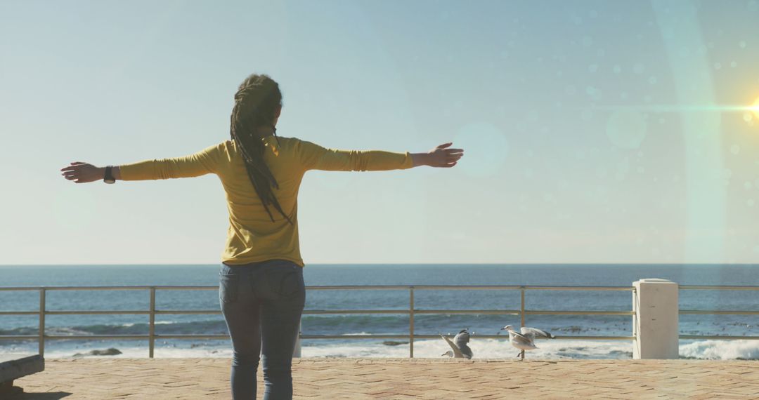 Woman Enjoying Sunny Day by the Ocean With Outstretched Arms - Free Images, Stock Photos and Pictures on Pikwizard.com