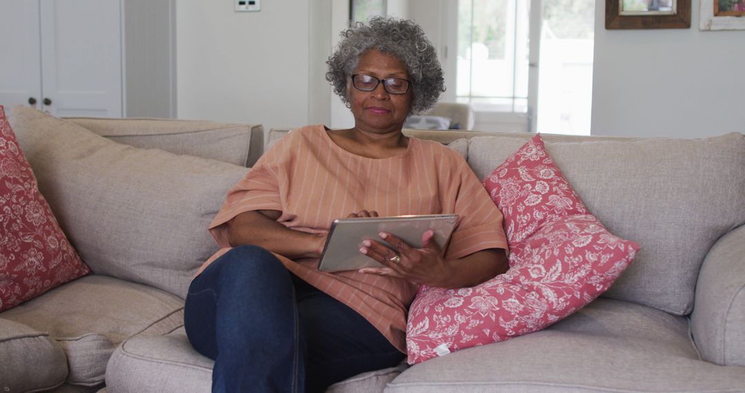 Senior Woman Relaxing on Couch with Digital Tablet at Home