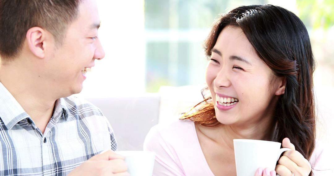 Couple Enjoying Morning Coffee and Laughing Together - Free Images, Stock Photos and Pictures on Pikwizard.com