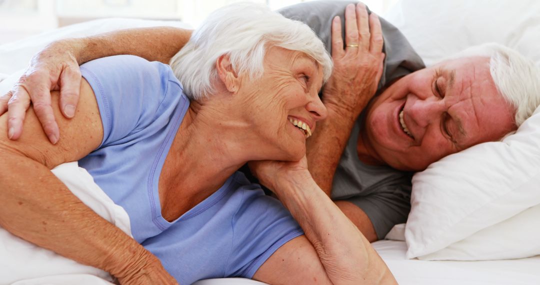 Smiling Senior Couple Relaxing in Comfortable Bedroom