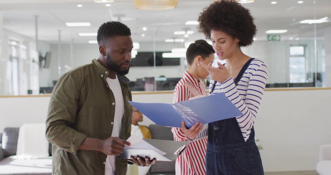 Coworkers Collaborating in Modern Office with Documents