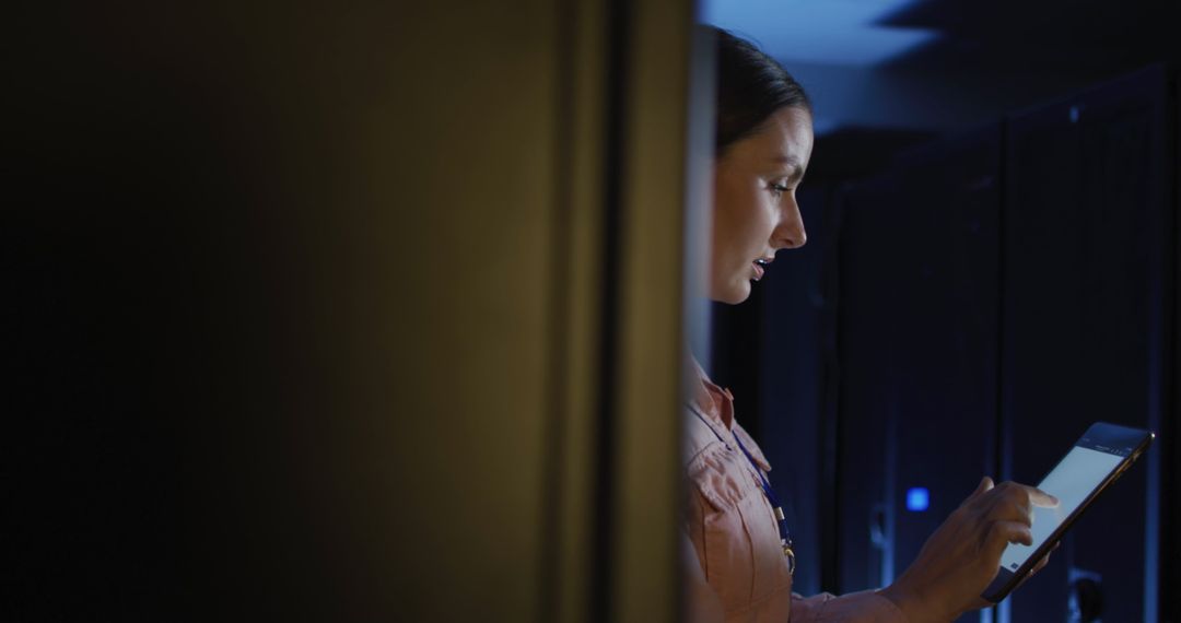 Engineer Monitoring Servers on Digital Tablet in Data Center