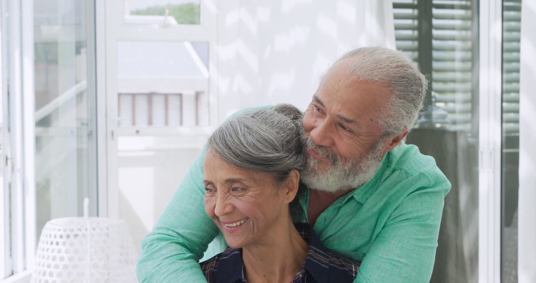 Elderly Couple Embracing in Sunlit Modern Home - Free Images, Stock Photos and Pictures on Pikwizard.com