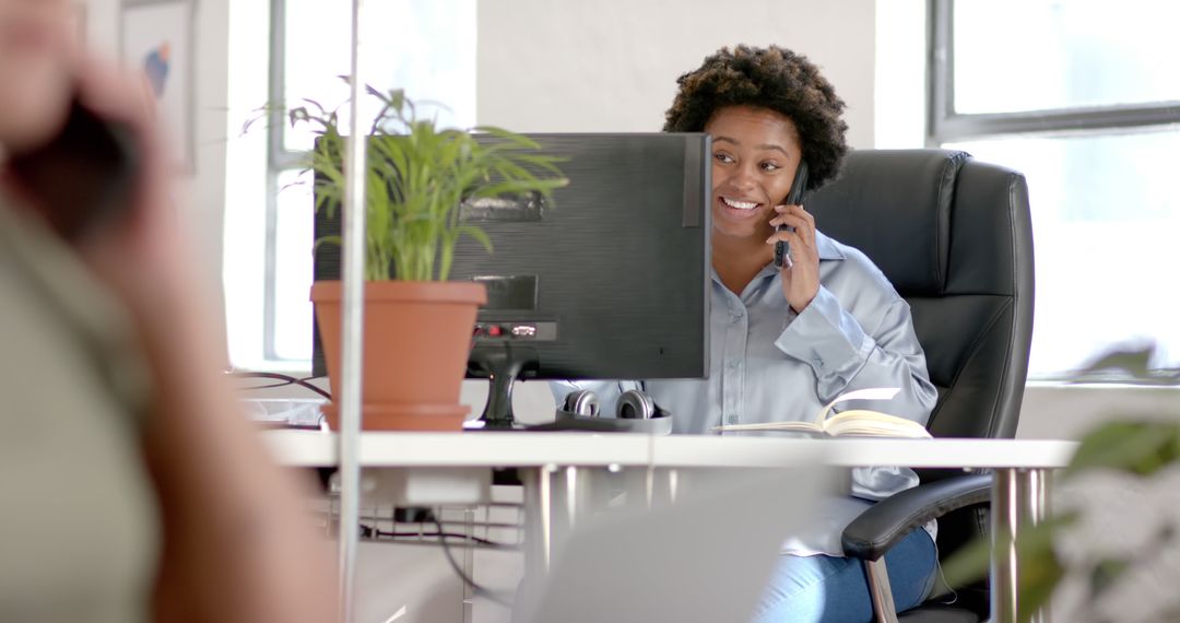 Smiling Businesswoman Taking Call at Office Desk