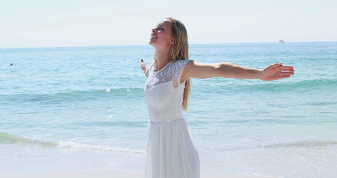 Woman in White Dress Enjoying Sea Breeze on Sunny Beach Day - Free Images, Stock Photos and Pictures on Pikwizard.com