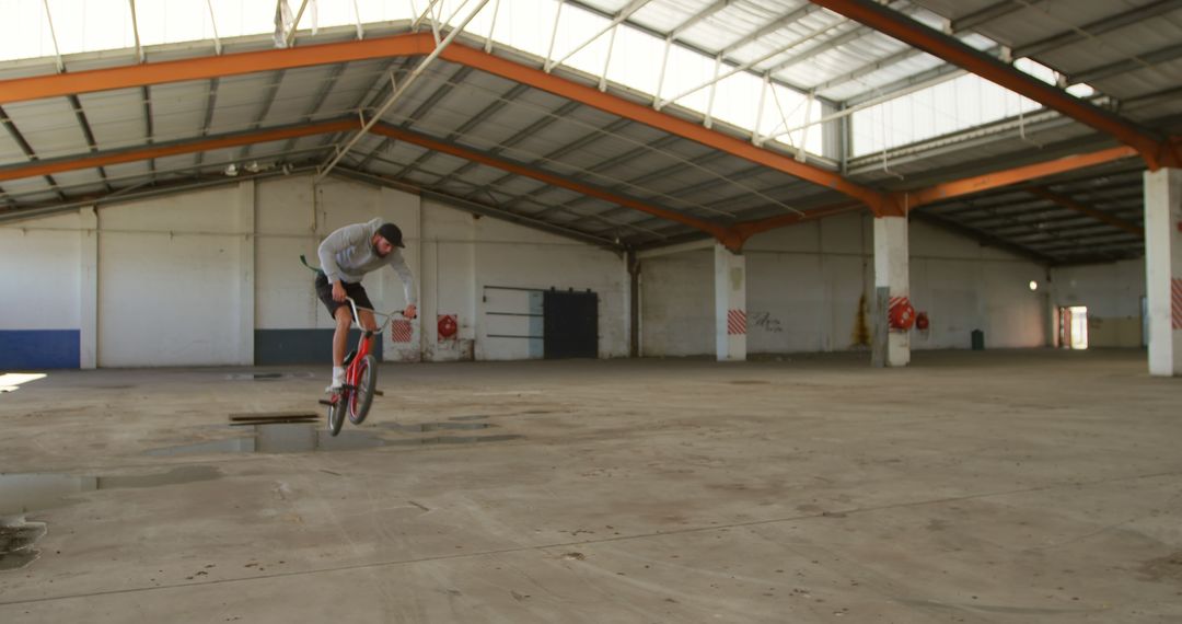 BMX Rider Performing Stunt Inside Abandoned Warehouse - Free Images, Stock Photos and Pictures on Pikwizard.com