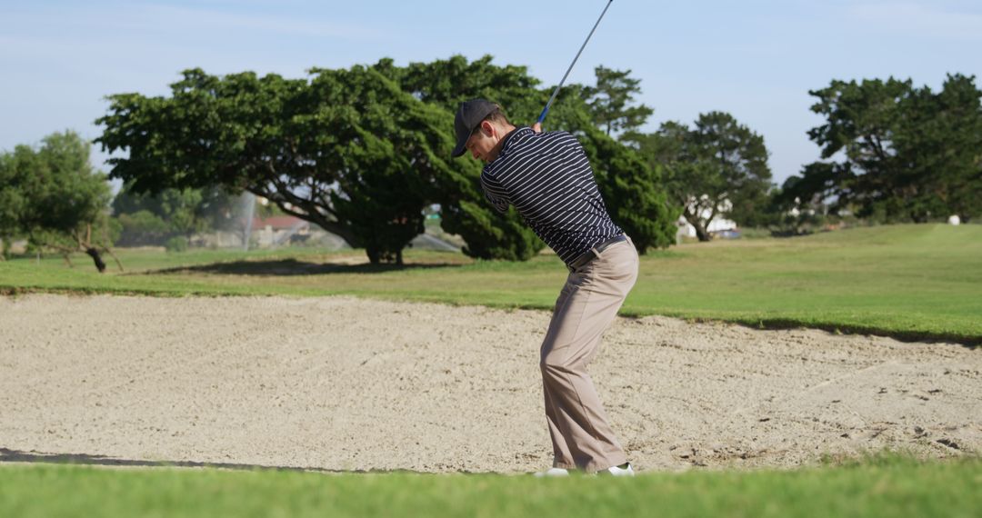 Golfer Hitting Ball from Sand Trap on a Sunny Day - Free Images, Stock Photos and Pictures on Pikwizard.com