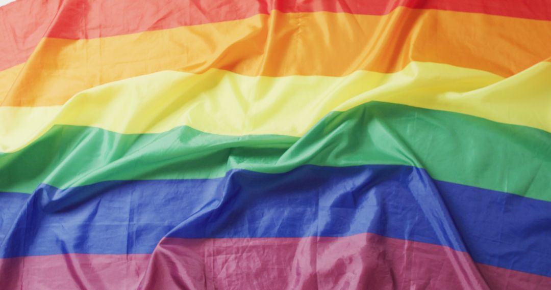 Image of creased rainbow flag lying on white background - Free Images, Stock Photos and Pictures on Pikwizard.com