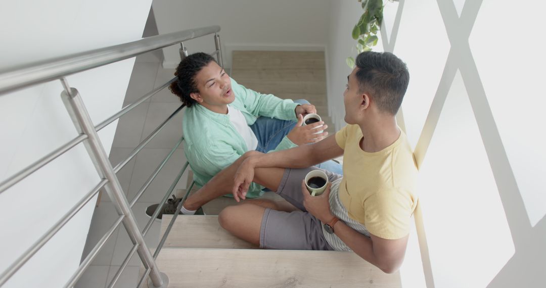 Two Friends Talking and Drinking Coffee on Staircase - Free Images, Stock Photos and Pictures on Pikwizard.com