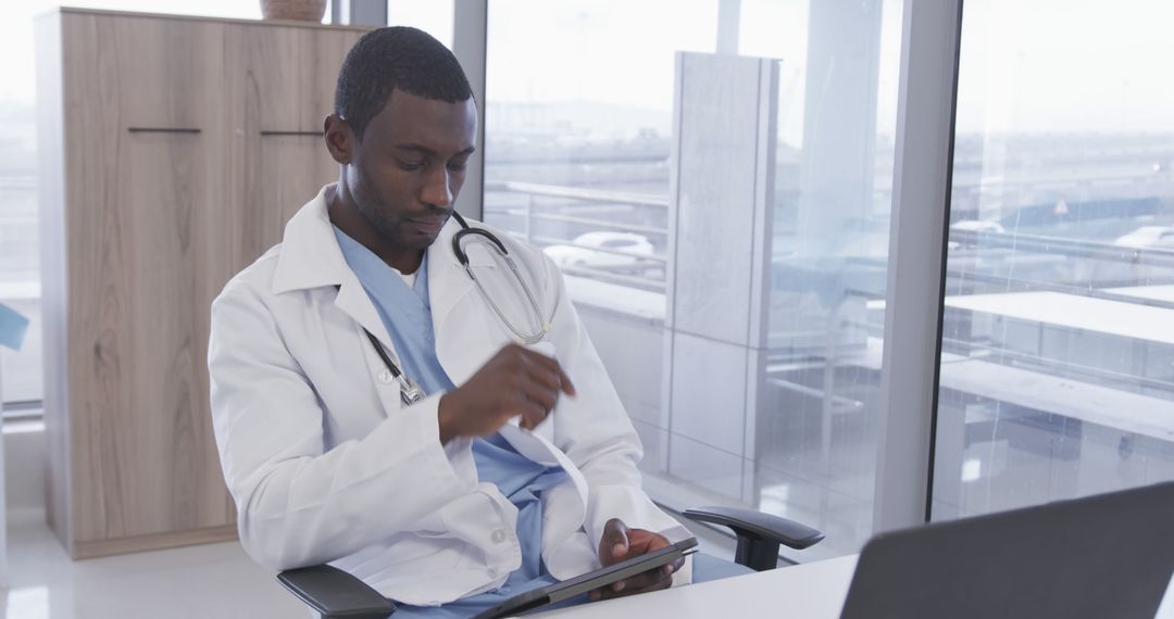 African American Doctor Using Tablet in Modern Medical Office - Free Images, Stock Photos and Pictures on Pikwizard.com