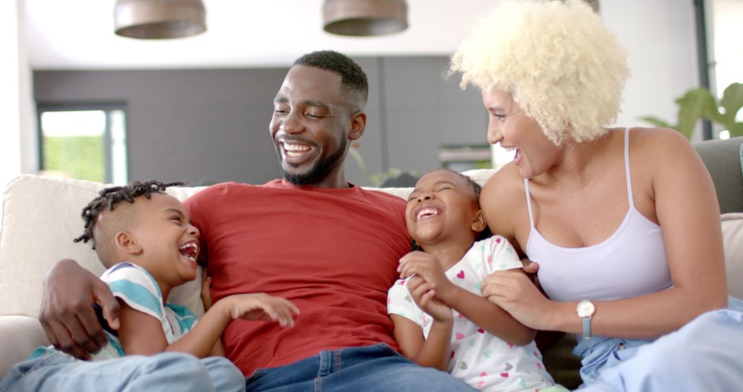 Happy African American Family Laughing Together on Couch