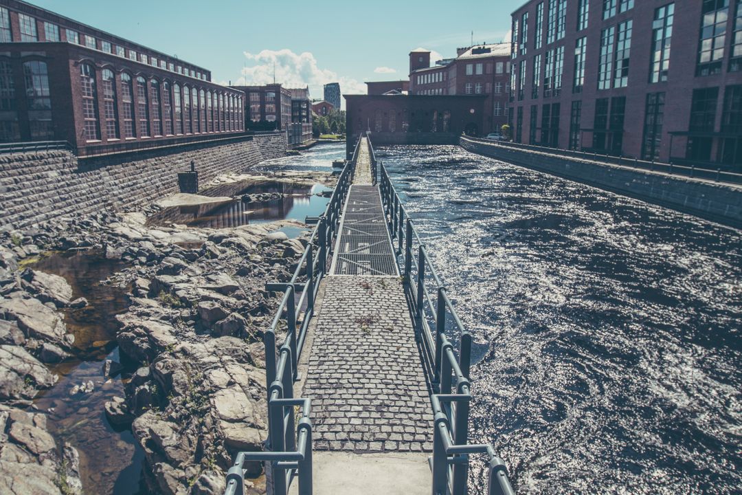 Historic Industrial Waterway with Cobblestone Path and Brick Buildings - Free Images, Stock Photos and Pictures on Pikwizard.com