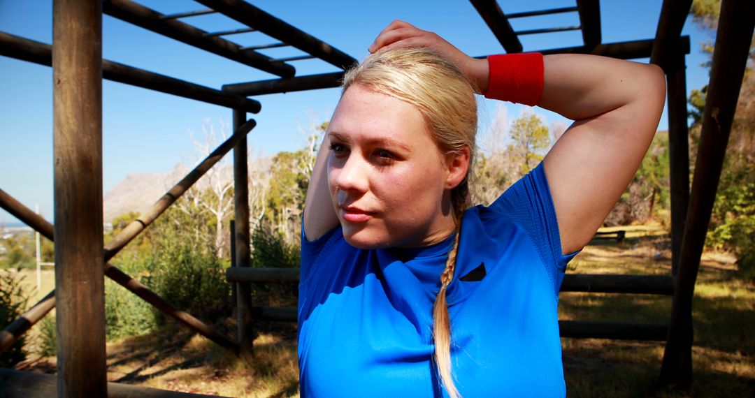 Fit Woman Stretching Under Obstacle Course Structure on Sunny Day - Free Images, Stock Photos and Pictures on Pikwizard.com