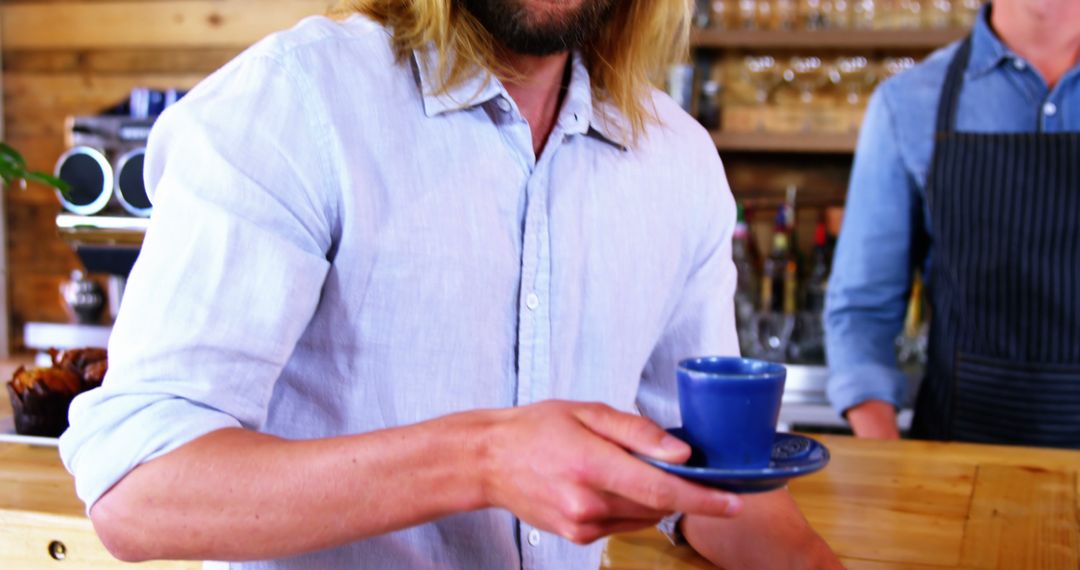 Caucasian man holding blue cup on plate in cafe, copy space - Free Images, Stock Photos and Pictures on Pikwizard.com