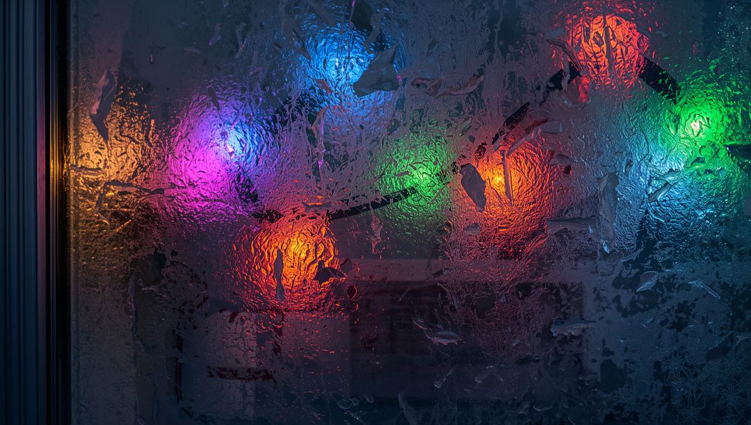 Frosted Window Glowing with Colorful String Lights Through Condensation
