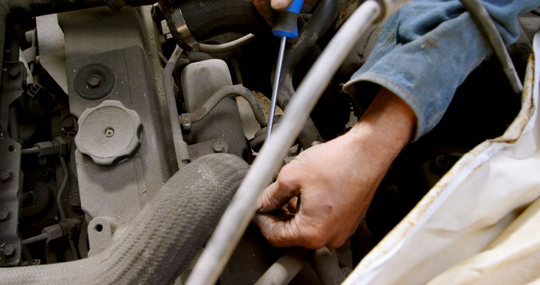 Mechanic Repairing Car Engine with Screwdriver Close-Up - Free Images, Stock Photos and Pictures on Pikwizard.com