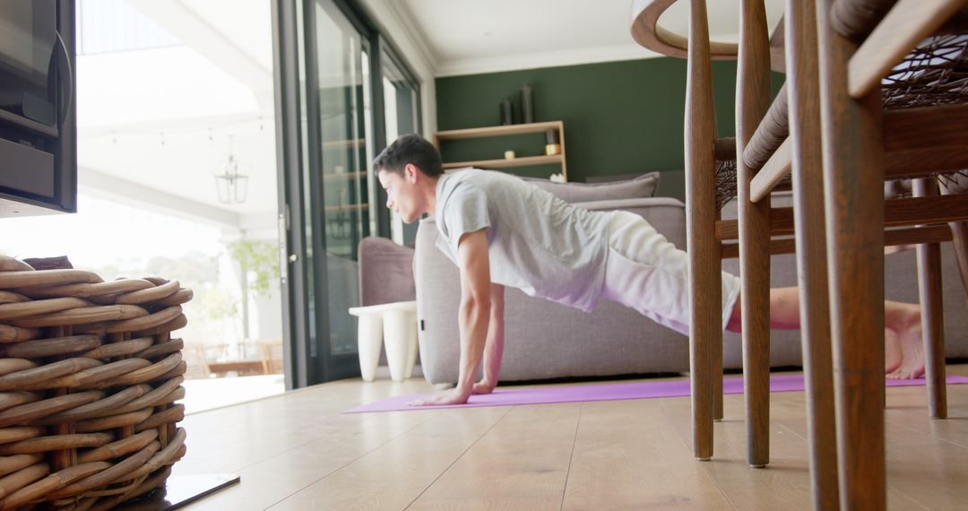 Focused Biracial Man Practicing Yoga Indoors with Relaxed Ambiance