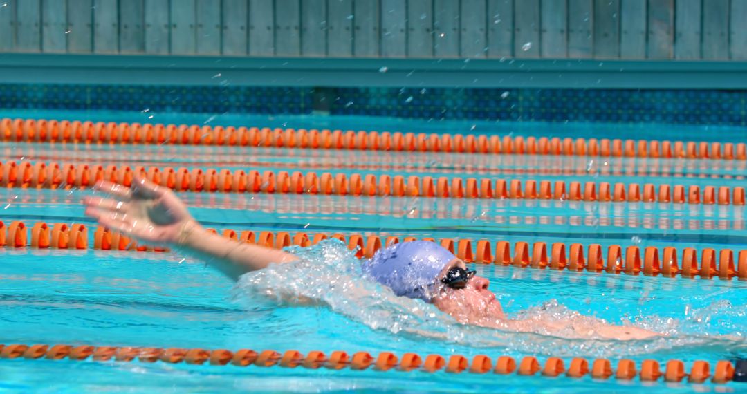 Swimmer Backstroking in Olympic Pool with Water Splash - Free Images, Stock Photos and Pictures on Pikwizard.com