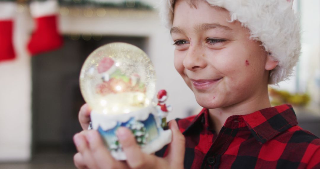 Young Boy Enjoying Christmas Snow Globe Display - Free Images, Stock Photos and Pictures on Pikwizard.com