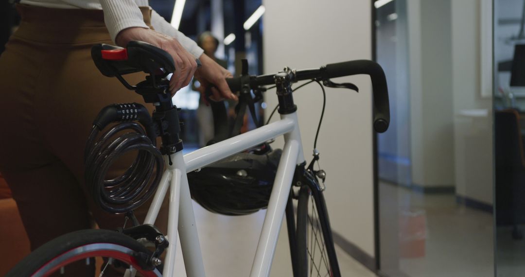 Person Holding Bicycle in Modern Office Hallway - Free Images, Stock Photos and Pictures on Pikwizard.com