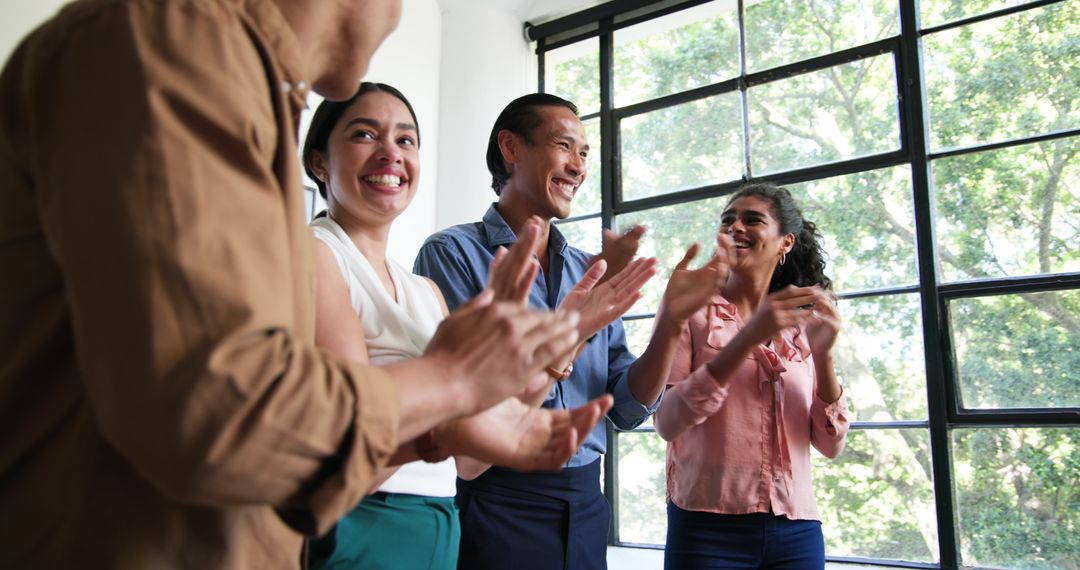 Diverse Team Clapping Together in Modern Office Environment