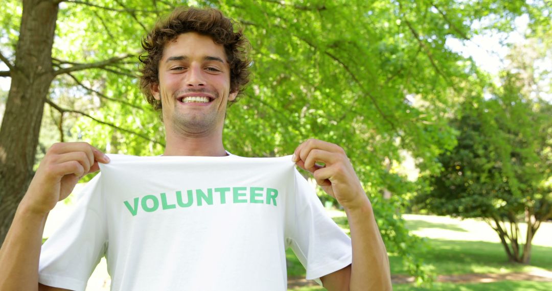 Smiling Young Man Wearing Volunteer T-Shirt in Park - Free Images, Stock Photos and Pictures on Pikwizard.com