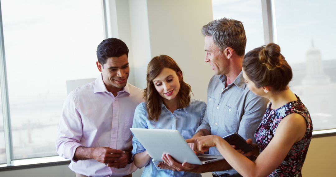 Executives Collaborating in Bright Office While Viewing Laptop