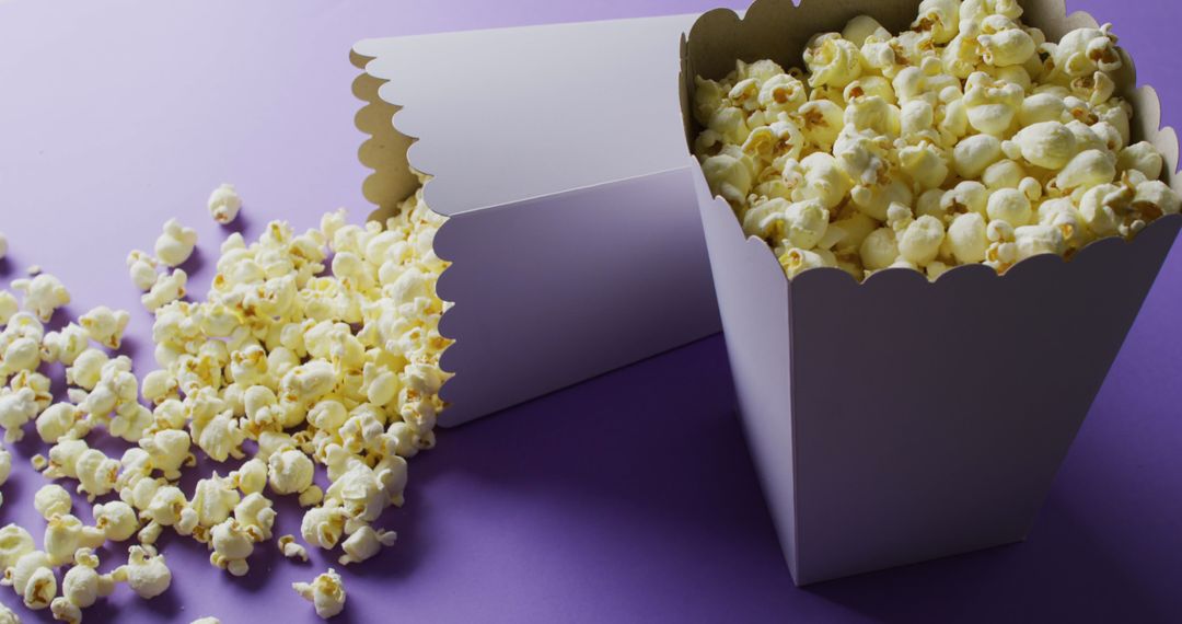 White Popcorn Tubs With Spilled Kernels On Purple Background - Free Images, Stock Photos and Pictures on Pikwizard.com