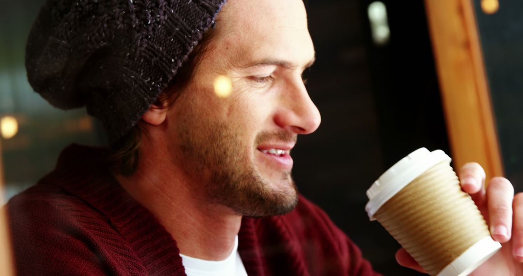 Man Wearing Beanie Drinking Coffee at Cafe Window - Free Images, Stock Photos and Pictures on Pikwizard.com