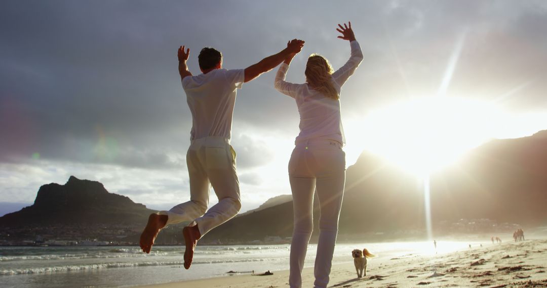 Happy Couple Jumping on Beach at Sunset - Free Images, Stock Photos and Pictures on Pikwizard.com