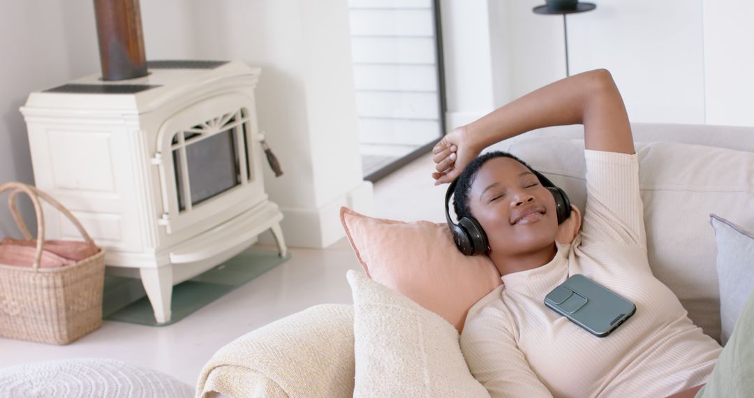 Relaxed Smiling Woman Listening to Music on Couch with Headphones - Free Images, Stock Photos and Pictures on Pikwizard.com