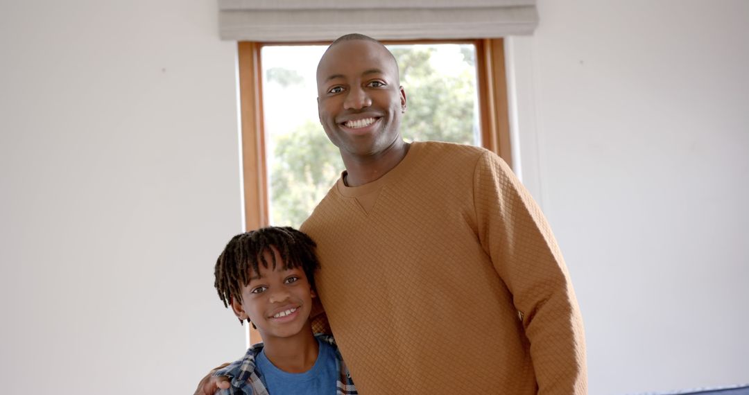 Happy Father and Son Smiling in Bright Living Room - Free Images, Stock Photos and Pictures on Pikwizard.com