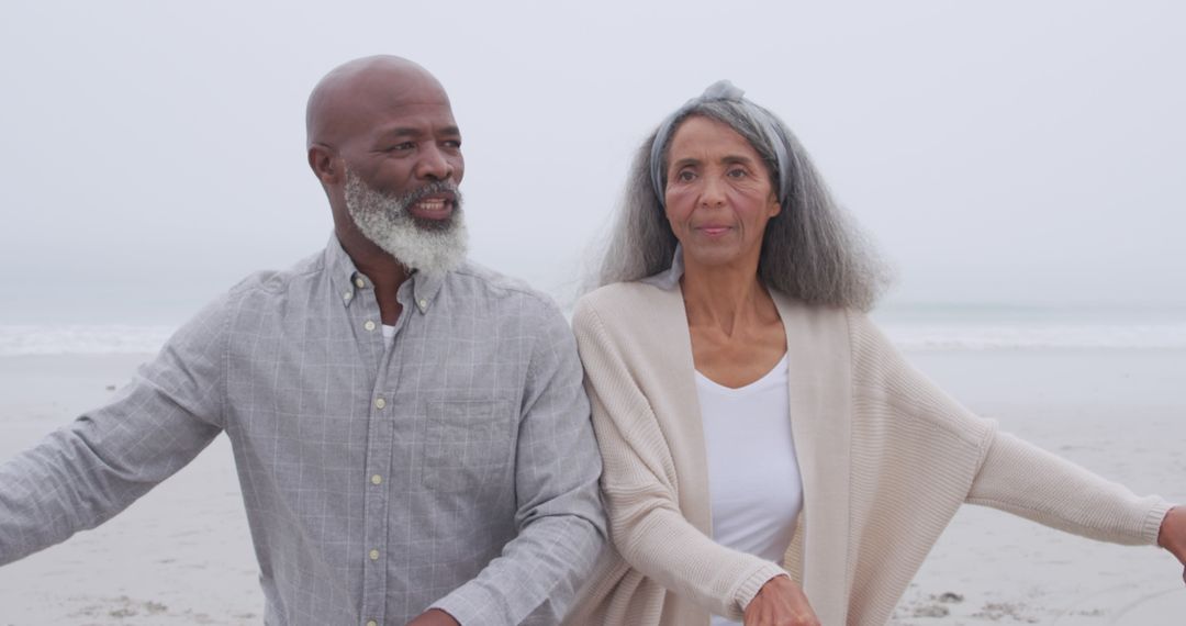 Senior African American Couple Enjoying Beach Walk on Foggy Day - Free Images, Stock Photos and Pictures on Pikwizard.com