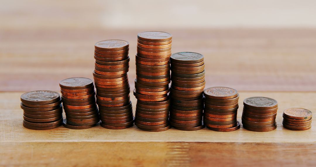 Stacked coins with rise and fall pattern on wood table - Free Images, Stock Photos and Pictures on Pikwizard.com